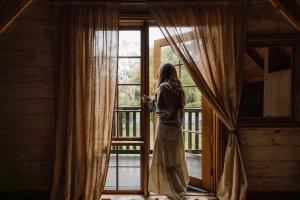 a woman is looking out of a window at The Quarters in Strahan