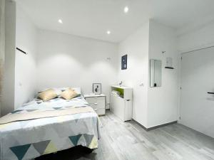 - une chambre blanche avec un lit et un réfrigérateur dans l'établissement Fantastico Apartamento Centro, à Madrid
