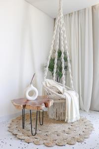 a white swing in a room with a table at Designer Seaview Condo in Gleem in Alexandria