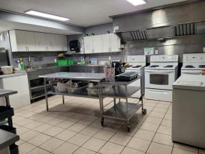 a kitchen with white appliances and a table in it at Banff International Hostel in Banff