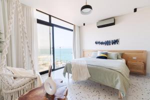 a bedroom with a bed and a large window at Designer Seaview Condo in Gleem in Alexandria