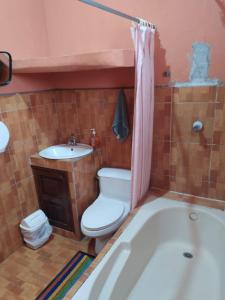uma casa de banho com uma banheira, um WC e um lavatório. em Ciudad Vieja Bed & Breakfast Hotel em Guatemala
