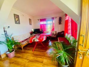 a living room with a couch and a table at Aroma Homestay in Kalimpong