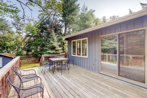a wooden deck with a table and chairs on it at Wanderlust in Glen Arbor