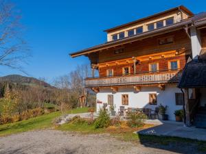 Cette grande maison en bois dispose d'un balcon sur une colline. dans l'établissement Schlafhamhof, à Hopfgarten im Brixental
