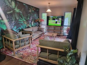 a living room with a couch and a tv at Hatea Treehouse in Whangarei