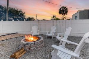 a group of white chairs sitting around a fire pit at PCB Group Retreat with Deck, 1 Block to Beach! in Panama City Beach