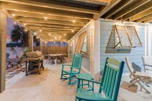 a patio with chairs and tables on a house at PCB Group Retreat with Deck, 1 Block to Beach! in Panama City Beach