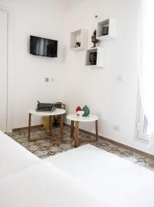 a room with two tables and a tv on the wall at Bellavista apartment in Caltagirone