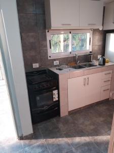 a kitchen with a stove and a sink at MAIPU Apart in Maipú