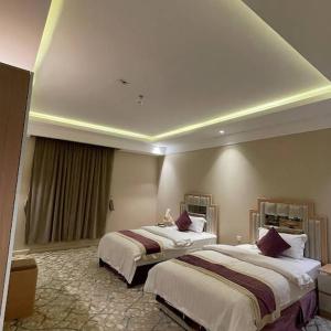 una habitación de hotel con 2 camas en una habitación en فندق العزم, en Hafr Al Batin