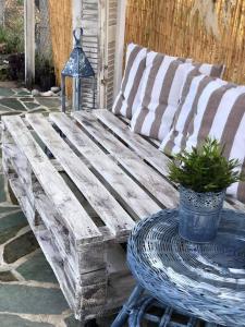 un banco de madera sentado en un patio con una mesa en Ευχάριστο εξοχικό σπίτι!, en AgiaKampos