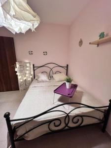 1 dormitorio con 1 cama con mesa púrpura en Ευχάριστο εξοχικό σπίτι!, en AgiaKampos
