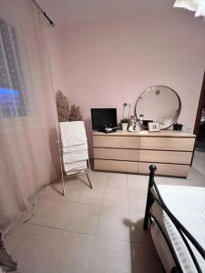 1 dormitorio con tocador con espejo y silla en Ευχάριστο εξοχικό σπίτι!, en AgiaKampos