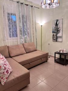 sala de estar con sofá y mesa en Ευχάριστο εξοχικό σπίτι!, en AgiaKampos