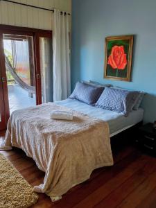 Un dormitorio con una cama con una rosa roja. en Casa do Mirante quarto 303 en Florianópolis