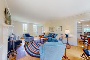 sala de estar con sofá azul y sillas en Miller Creek Cove Retreat, en Brunswick