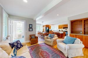 a living room with two couches and a kitchen at Miller Creek Cove Retreat in Brunswick