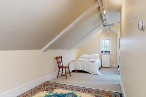 a attic room with a bed and a chair at Miller Creek Cove Retreat in Brunswick