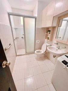 a white bathroom with a toilet and a sink at Mesaverte Residences T2-8H in Cagayan de Oro