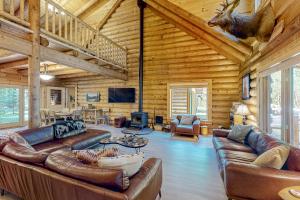 a living room with leather furniture in a log cabin at Misty Mountain Lodge in Tillamook