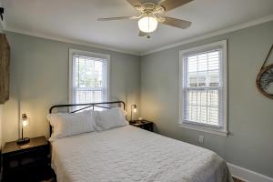 a bedroom with a bed with a ceiling fan and two windows at Pura Vida - B -Murrells Inlet in Myrtle Beach