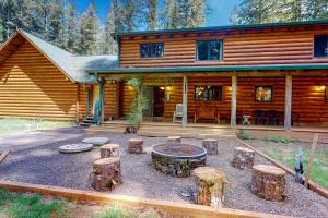 a log cabin with a fire pit in front of it at Misty Mountain Lodge in Tillamook