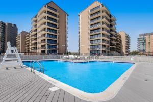 een zwembad met twee hoge appartementsgebouwen op de achtergrond bij Sea Colony --- 39353 W Pine Ct #1009C in Bethany Beach