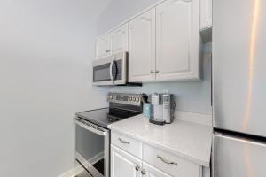 een keuken met witte kasten en een roestvrijstalen koelkast bij Sea Colony --- 39353 W Pine Ct #1009C in Bethany Beach