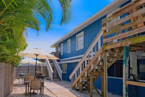 a blue building with a wooden deck and a table and chairs at Longboard in Holmes Beach