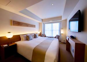 a hotel room with a large bed and a flat screen tv at THE GENERAL KYOTO Bukkouji Shinmachi in Kyoto