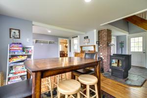 a living room with a wooden table and a fireplace at Vermont Vacation Rental Hot Tub, Near Ski Resorts in Mount Holly
