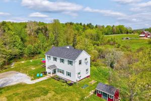 an aerial view of a white house on a field at Vermont Vacation Rental Hot Tub, Near Ski Resorts in Mount Holly