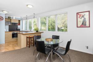 cocina y comedor con mesa y sillas en Village Apartment Havelock North en Havelock North