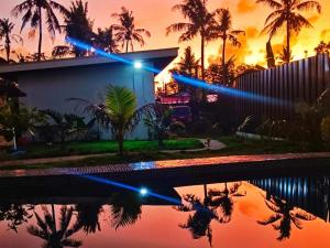 une maison avec une piscine en face d'un coucher de soleil dans l'établissement Amara Family 2Br House, pool, 180Mbps, garden , parking Central location, à General Luna