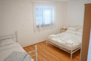 2 łóżka w białym pokoju z oknem w obiekcie Apartments with a parking space Marina, Trogir - 21358 w Marinie