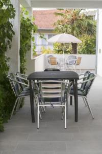 czarny stół z krzesłami i parasolem w obiekcie Apartments with a parking space Marina, Trogir - 21358 w Marinie