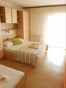 a bedroom with two beds and a large window at Apartments with parking space Zivogosce - Blato, Makarska - 21271 in Živogošće