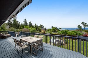 una terraza de madera con mesa y sillas. en Admirals Cove, en Coupeville