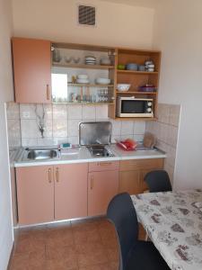 a small kitchen with a sink and a microwave at Apartments with parking space Zivogosce - Blato, Makarska - 21271 in Živogošće