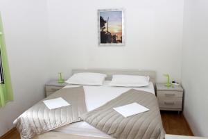 une chambre avec un lit avec deux oreillers blancs dans l'établissement Apartments by the sea Podgora, Makarska - 21378, à Podgora
