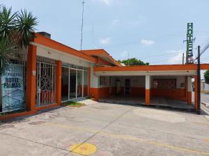 um edifício laranja e branco com um parque de estacionamento vazio em Palmas em Cuernavaca