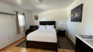 1 dormitorio con 1 cama y 1 silla en Cozy Rooms, en Homestead