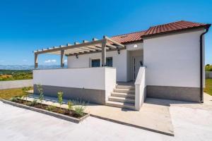 une petite maison blanche avec un mur blanc dans l'établissement Holiday House "Jere & Leon" - Villa With Sea View, à Ljubač