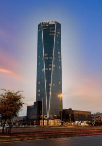 a tall glass building with a street in front of it at HDB Financial District in Riyadh