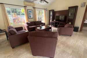 uma sala de estar com dois sofás e uma televisão em Casa Linda Private Pool Villa em Sosúa