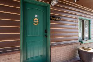 una puerta verde con el número seis en una casa en The Bucking Moose en West Yellowstone