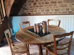 a wooden table with two cups on top of it at Cozy Holiday Home in Ceauc in Céaucé