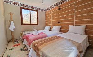 1 dormitorio con 2 camas y ventana en Toubkal Views, en Imlil