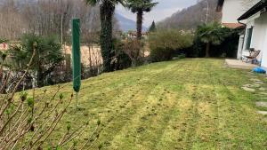 een tuin met een groene paal in het gras bij Villetta/5Rent in Muzzano